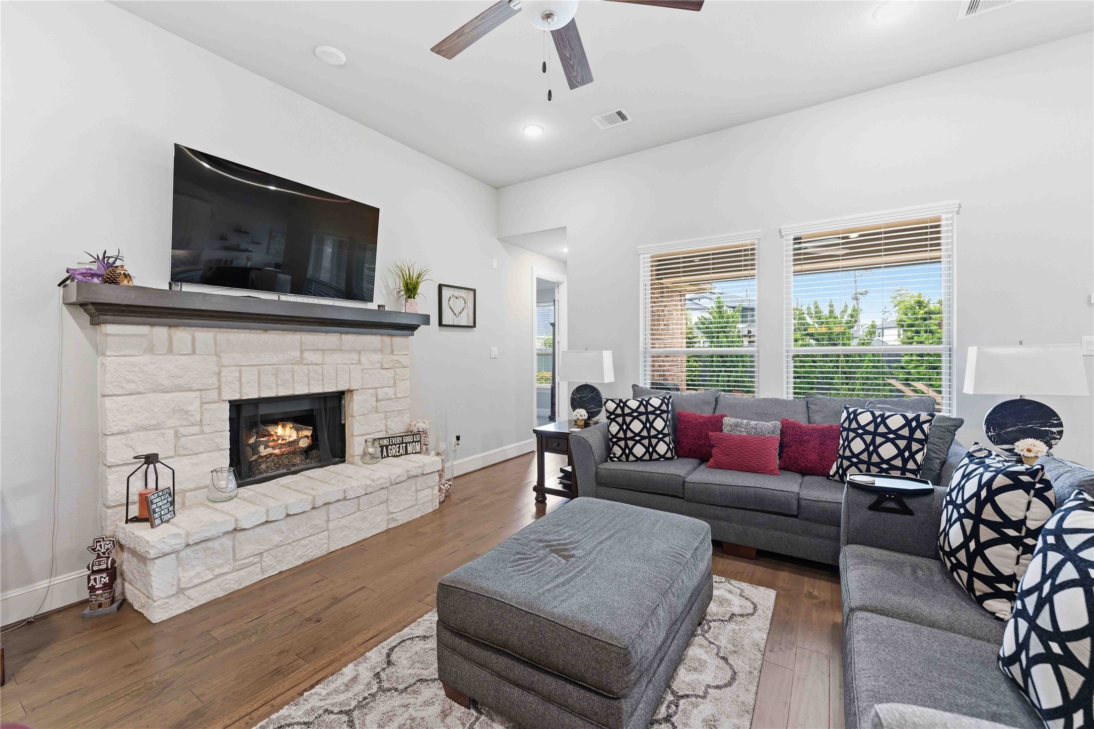 10127 Cooper's Hawk Way Conroe, TX 77385 - Photo 7 of 35 Spacious living room with lots of windows and abundant natural light adorned by a cozy fireplace