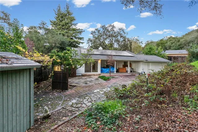 a view of a house with backyard and sitting area