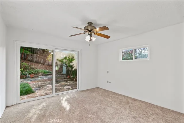 a view of a room with a ceiling fan and window