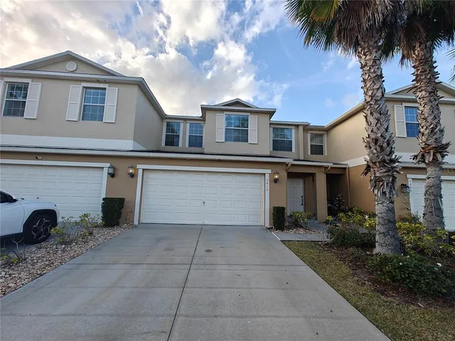 a view of a house with a yard and a large tree