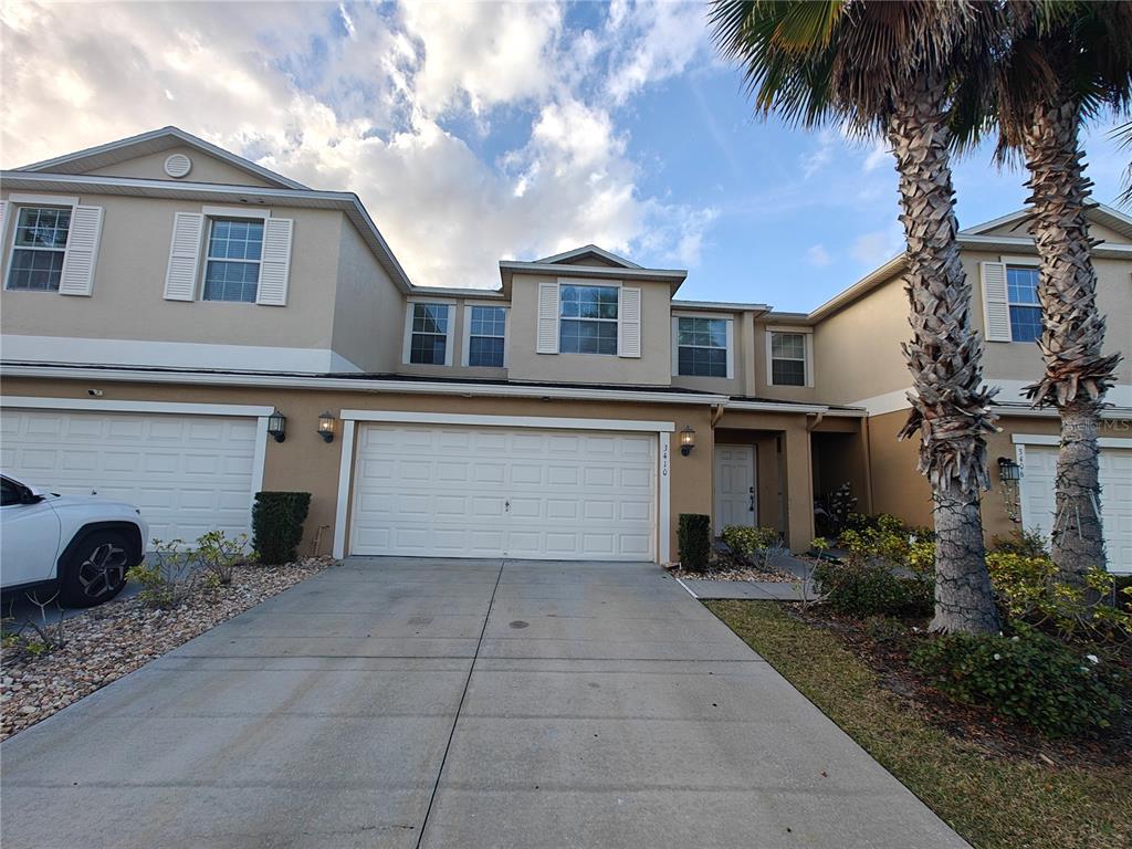a view of a house with a yard and a large tree