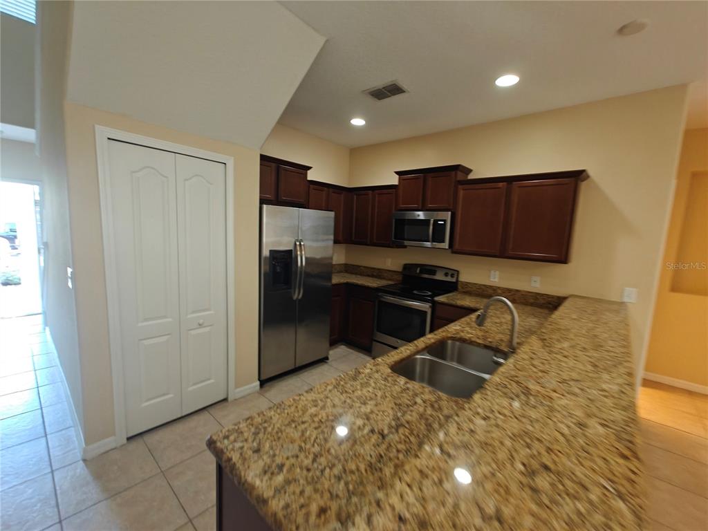 3410 Rodrick Circle Orlando, FL 32824 - Photo 2 of 27 a kitchen with stainless steel appliances granite countertop a refrigerator and a sink