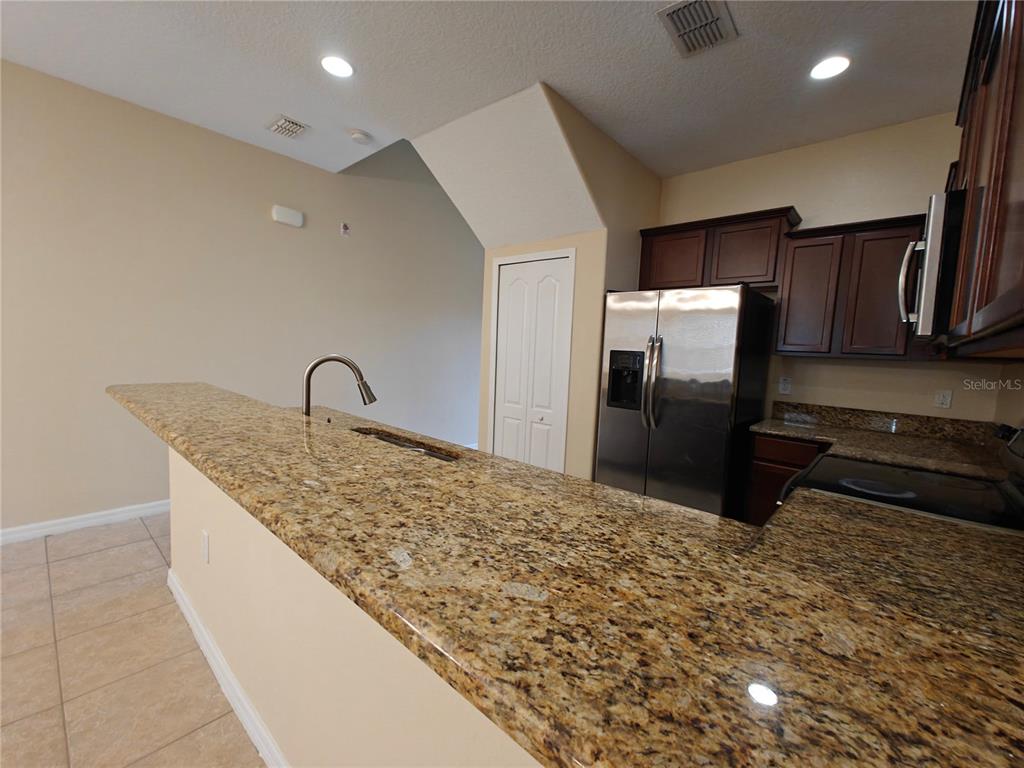 3410 Rodrick Circle Orlando, FL 32824 - Photo 3 of 27 a kitchen with granite countertop a refrigerator and a sink
