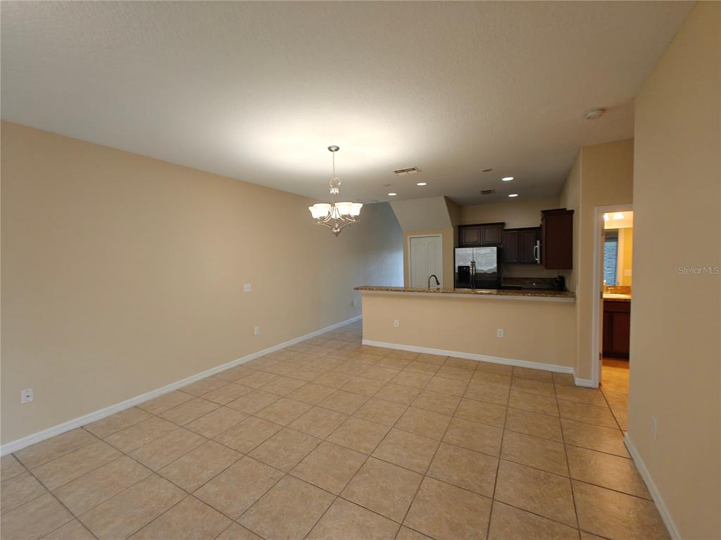 3410 Rodrick Circle Orlando, FL 32824 - Photo 6 of 27 an empty room with kitchen view and a window