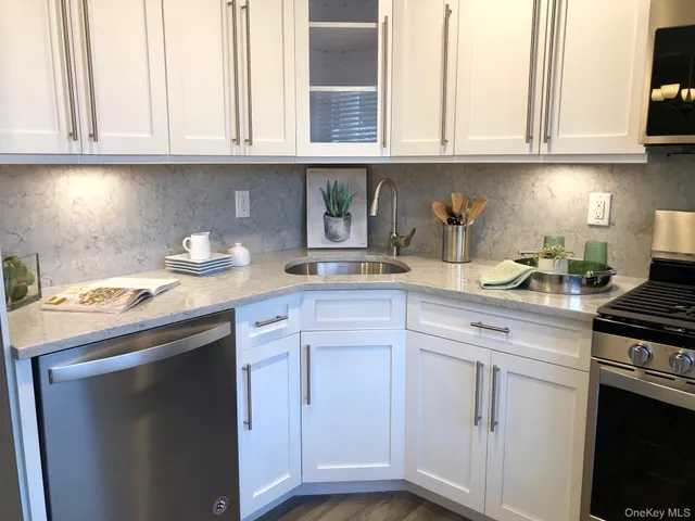 a kitchen with granite countertop white cabinets and a stove