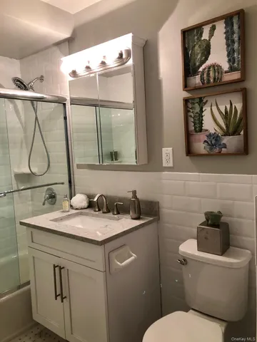 a bathroom with a granite countertop sink a toilet and a mirror