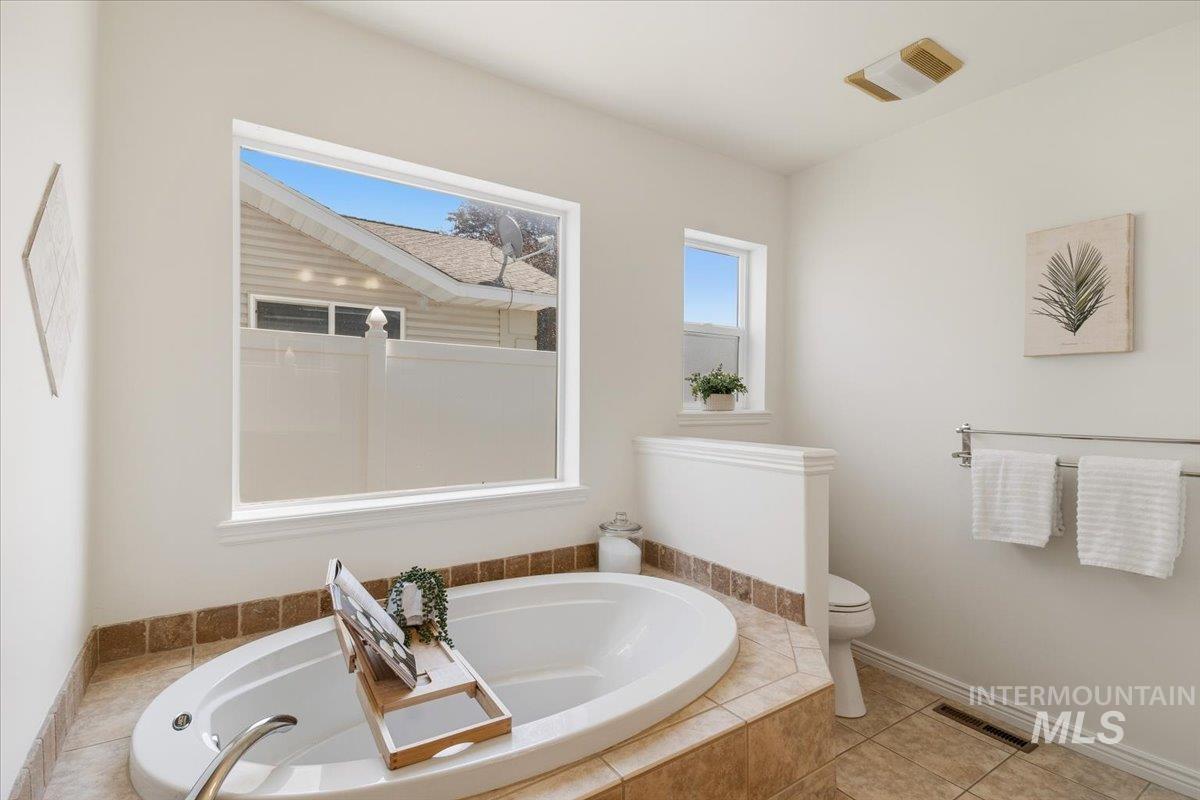 2032 Talus Loop Twin Falls, ID 83301 - Photo 37 of 43 Soaking tub with tile surround, large picture window, and neutral wall tones