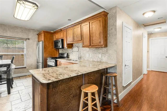 a kitchen with granite countertop a sink stove and refrigerator