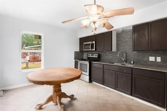 a kitchen with stainless steel appliances a sink cabinets and wooden floor