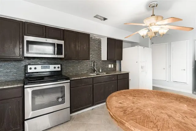 a kitchen with stainless steel appliances granite countertop a stove cabinets and microwave