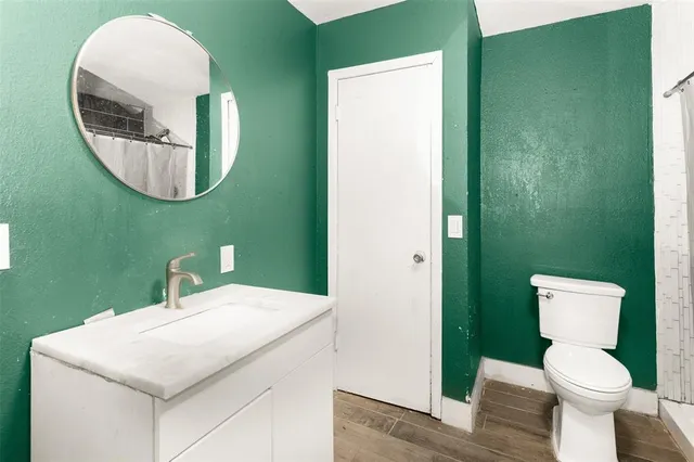 a bathroom with a toilet a sink and mirror