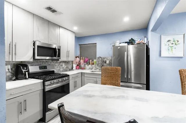 a kitchen with a refrigerator stove and sink