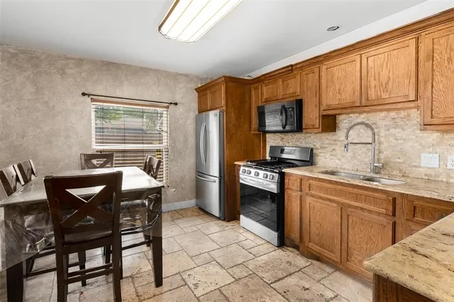 a kitchen with stainless steel appliances granite countertop a stove a sink dishwasher a microwave oven with granite countertops and cabinets