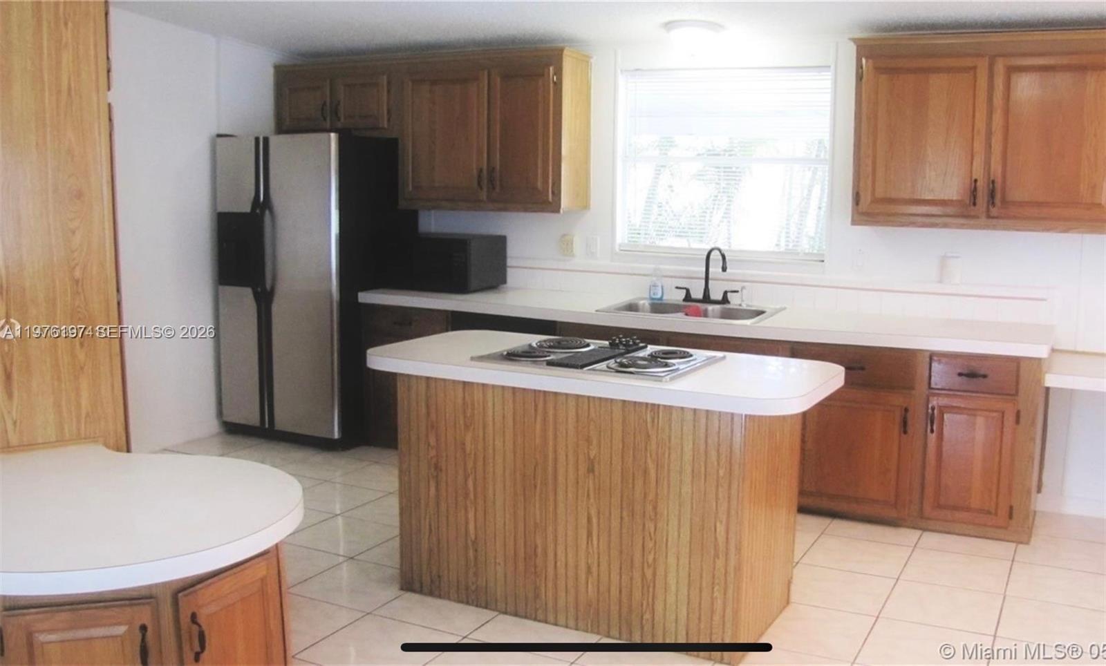 19800 Southwest 180th Avenue, Unit 320 Miami, FL 33187 - Photo 5 of 7 a kitchen with stainless steel appliances a refrigerator a sink a stove a counter space and cabinets