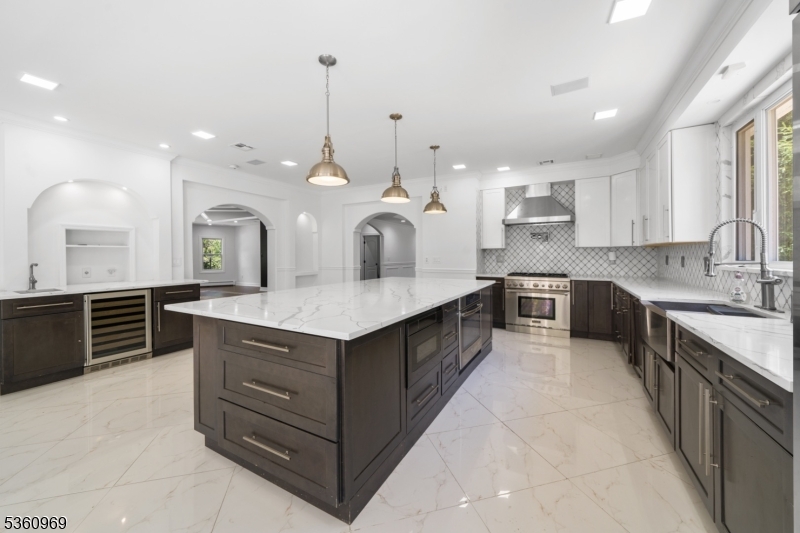 47 Cutlass Road Kinnelon, NJ 07405 - Photo 32 of 42 a large white kitchen with kitchen island a large island a sink stainless steel appliances and cabinets