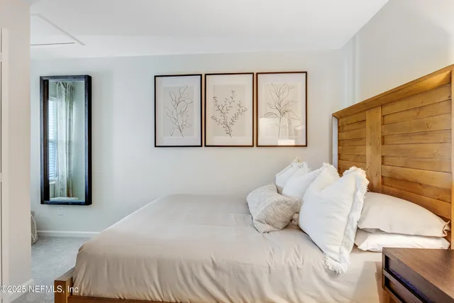 a bedroom with a bed and a painting on the wall