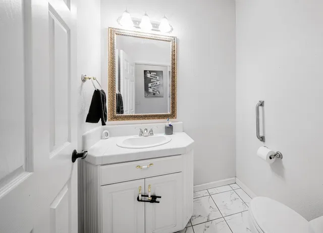 a bathroom with a sink a toilet and mirror