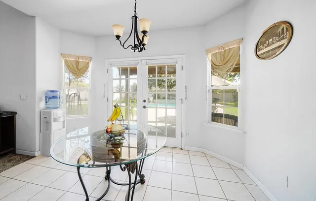 a view of a dining room with furniture a chandelier and wooden floor