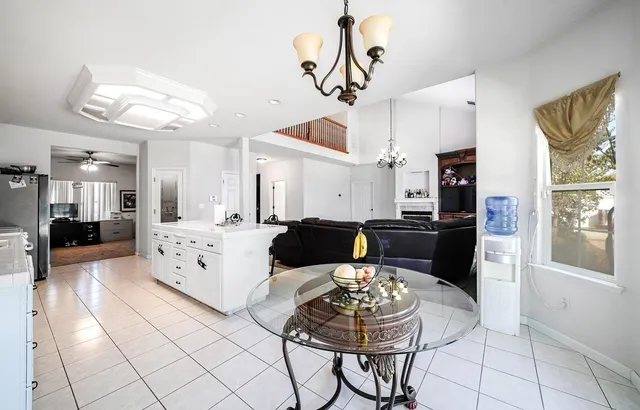 a kitchen with stainless steel appliances kitchen island granite countertop a refrigerator a stove a sink dishwasher and white cabinets with wooden floor