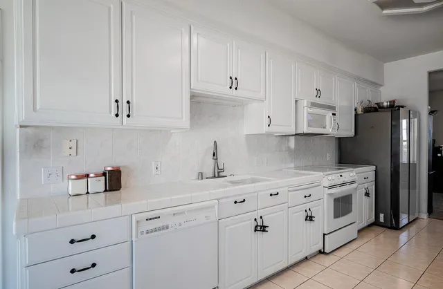 a kitchen with cabinets appliances a sink and a counter space