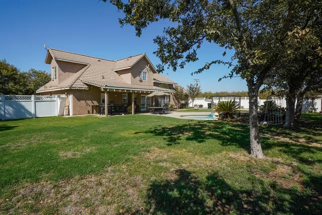 a view of a house with swimming pool and a yard