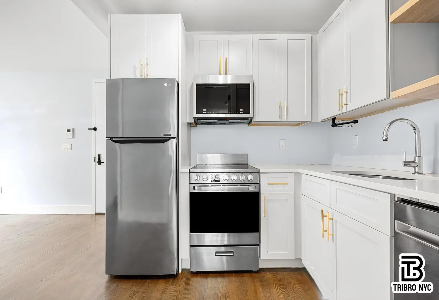 64 Stagg Street, Unit 4H Brooklyn, NY 11206 - Photo 6 of 7 a kitchen with stainless steel appliances a refrigerator stove and microwave
