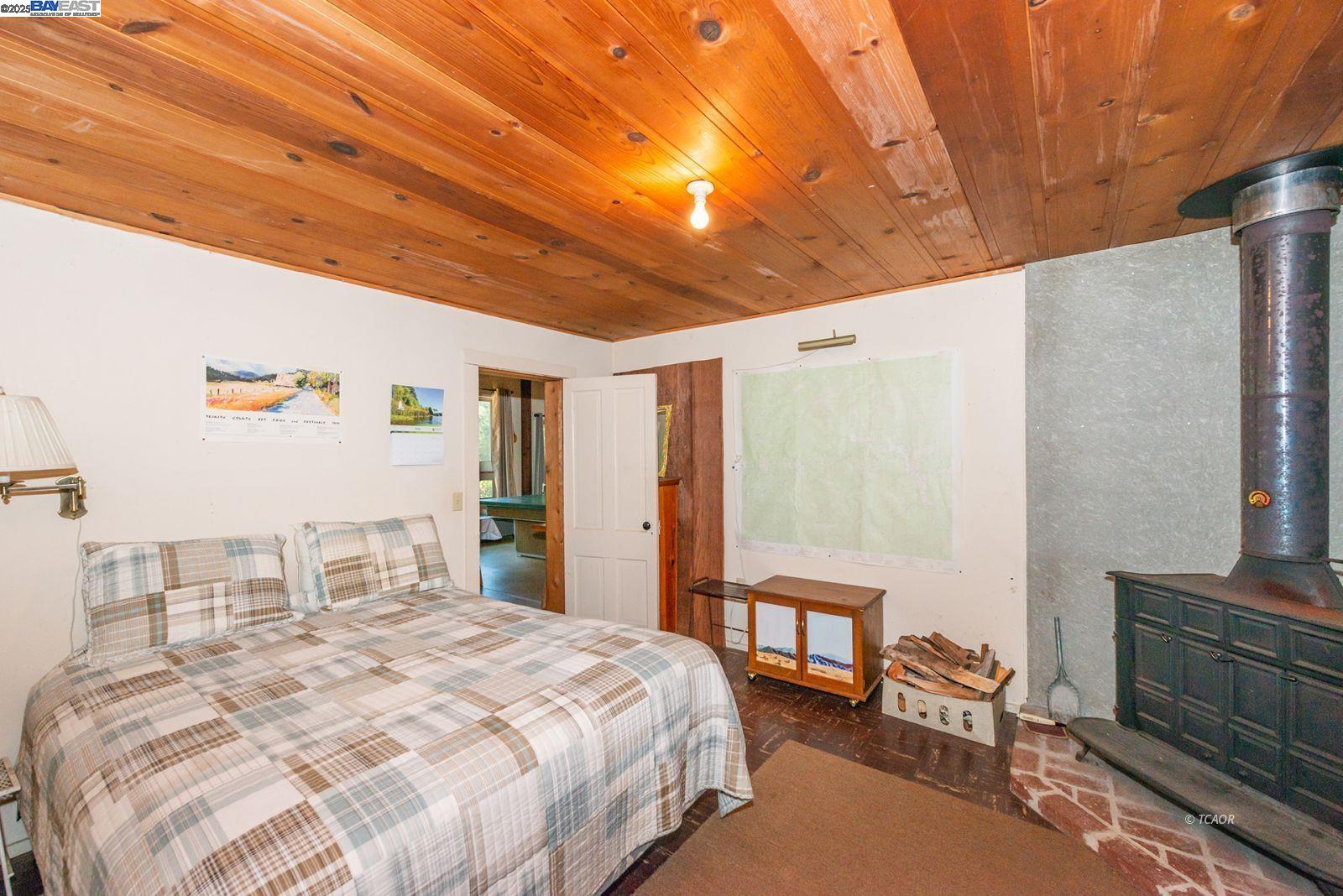 181 Price Creek Road Big Bar, CA 96010 - Photo 19 of 49 a bedroom with a bed and a chandelier