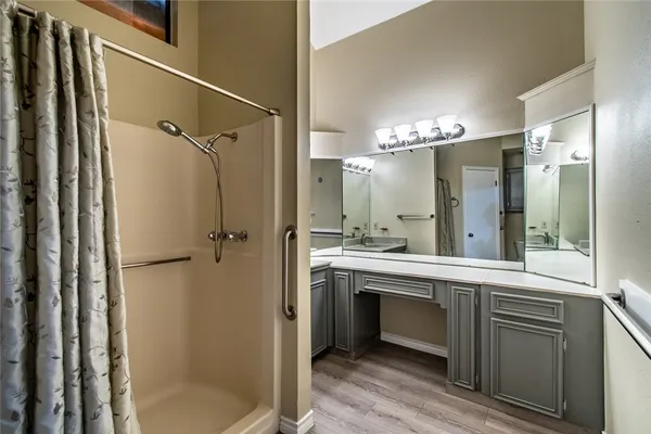 a bathroom with a double vanity sink mirror and shower