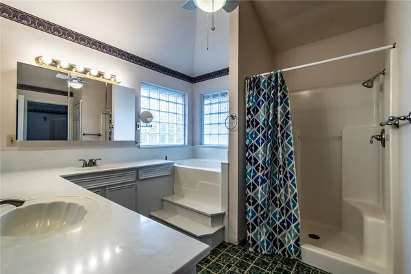 a bathroom with a bathtub sink vanity and a shower