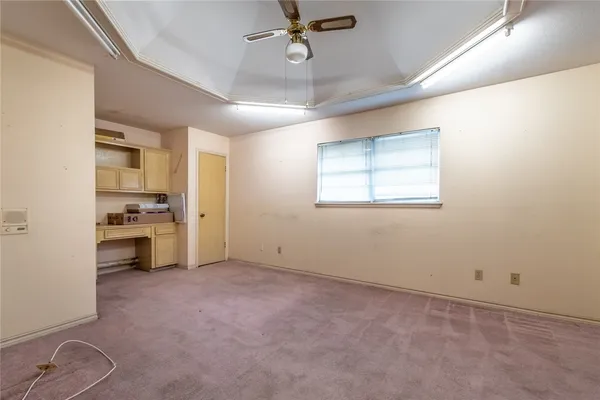 an empty room with windows and ceiling fan