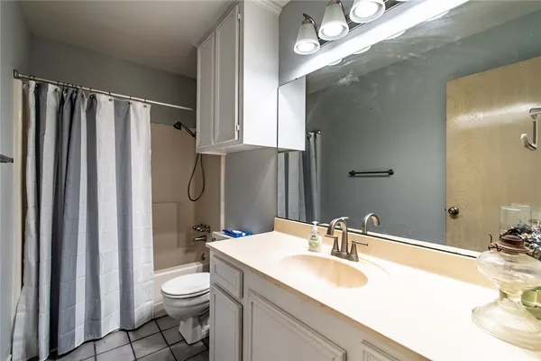 a bathroom with a sink a toilet a mirror and shower