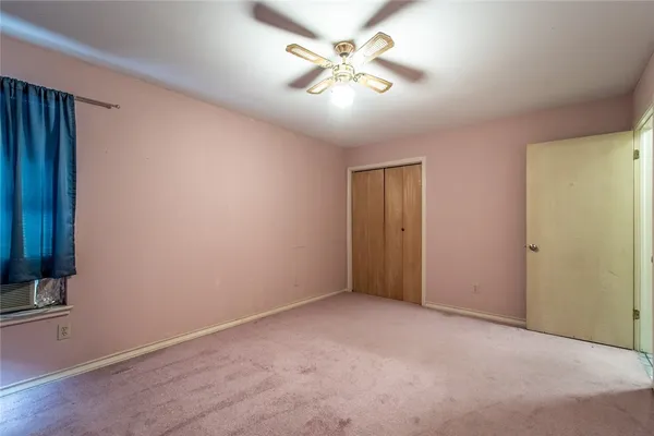 an empty room with a ceiling fan and a fan