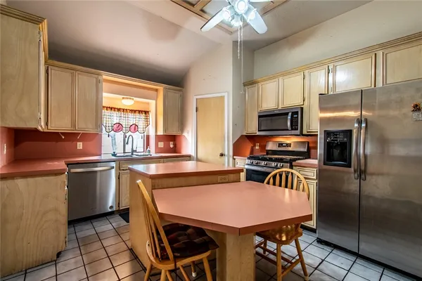 a kitchen with stainless steel appliances granite countertop a sink refrigerator stove and microwave