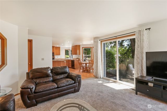 a living room with furniture a flat screen tv and a window