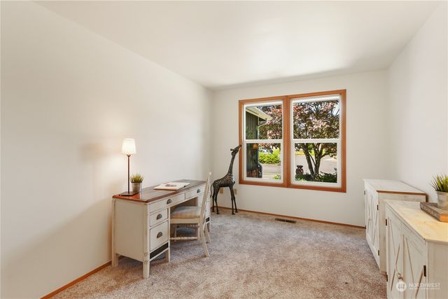 a view of a workspace with furniture and a window