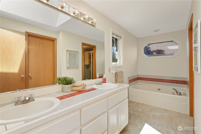 a bathroom with a tub sink and mirror