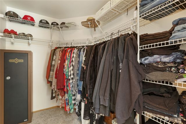 a view of walk in closet with clothes and shoes