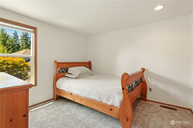 a bed sitting in a bedroom next to a window