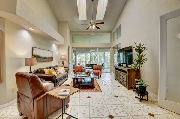 a living room with furniture a window and a potted plant