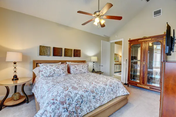 a bedroom with a large bed and a chandelier