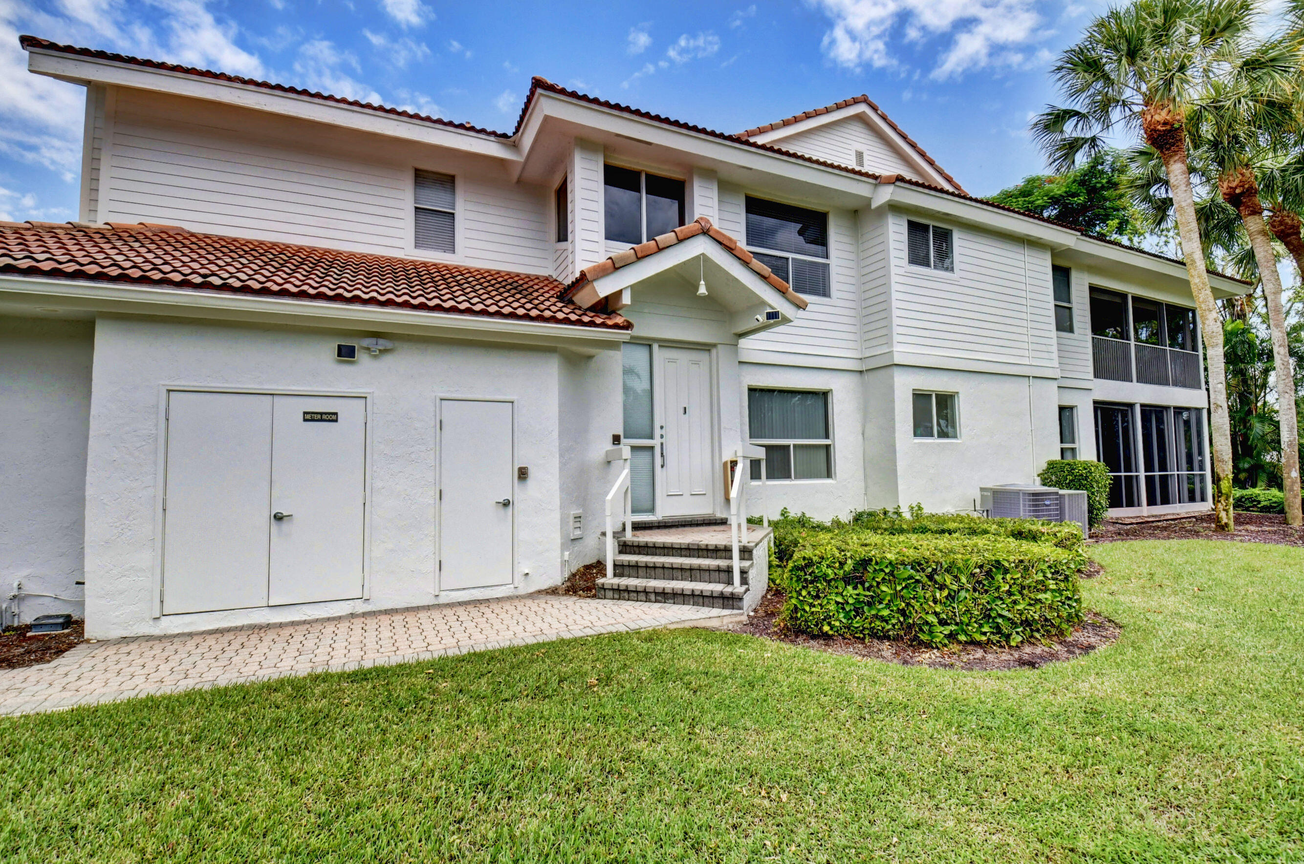 2464 Northwest 59th Street, Unit 1103 Boca Raton, FL 33496 - Photo 3 of 48 a front view of a house with a garden