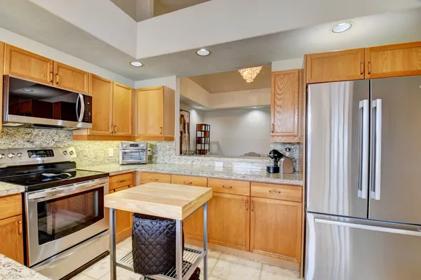 a kitchen with stainless steel appliances granite countertop a refrigerator stove and microwave
