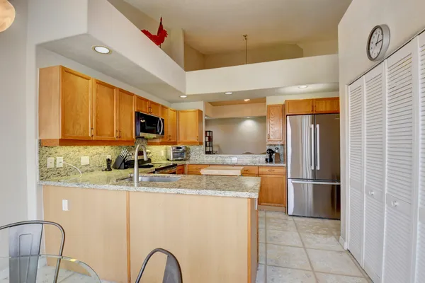 a kitchen with stainless steel appliances granite countertop a refrigerator and a stove top oven