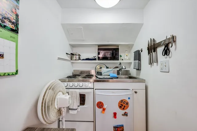 a kitchen with a stove and a white refrigerator