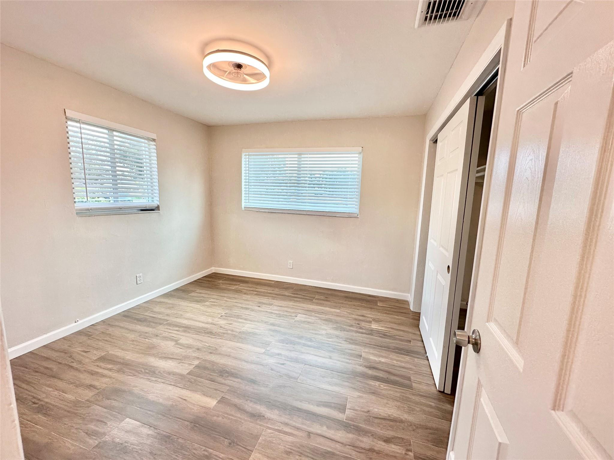 512 Southwest 11th Street, Unit A Hallandale Beach, FL 33009 - Photo 13 of 15 a view of an empty room with wooden floor and a window