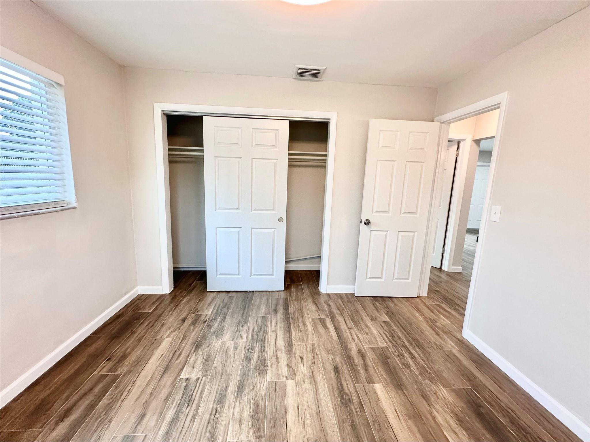 512 Southwest 11th Street, Unit A Hallandale Beach, FL 33009 - Photo 14 of 15 an empty room with wooden floor and closet