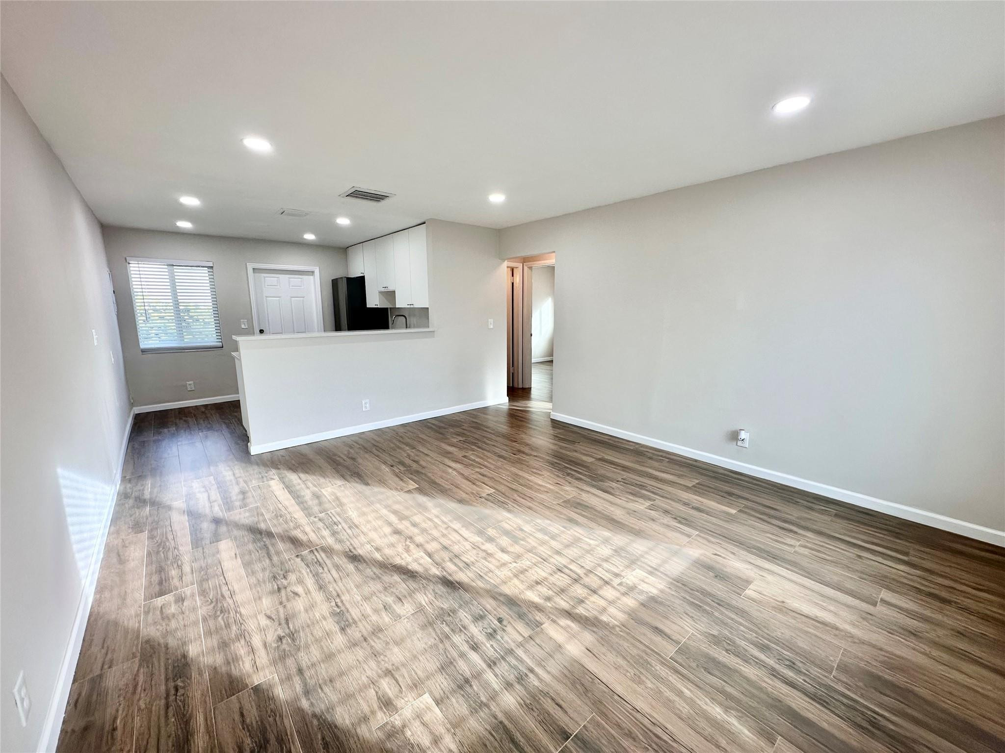 512 Southwest 11th Street, Unit A Hallandale Beach, FL 33009 - Photo 5 of 15 a view of a kitchen with kitchen island wooden floor center island and stainless steel appliances