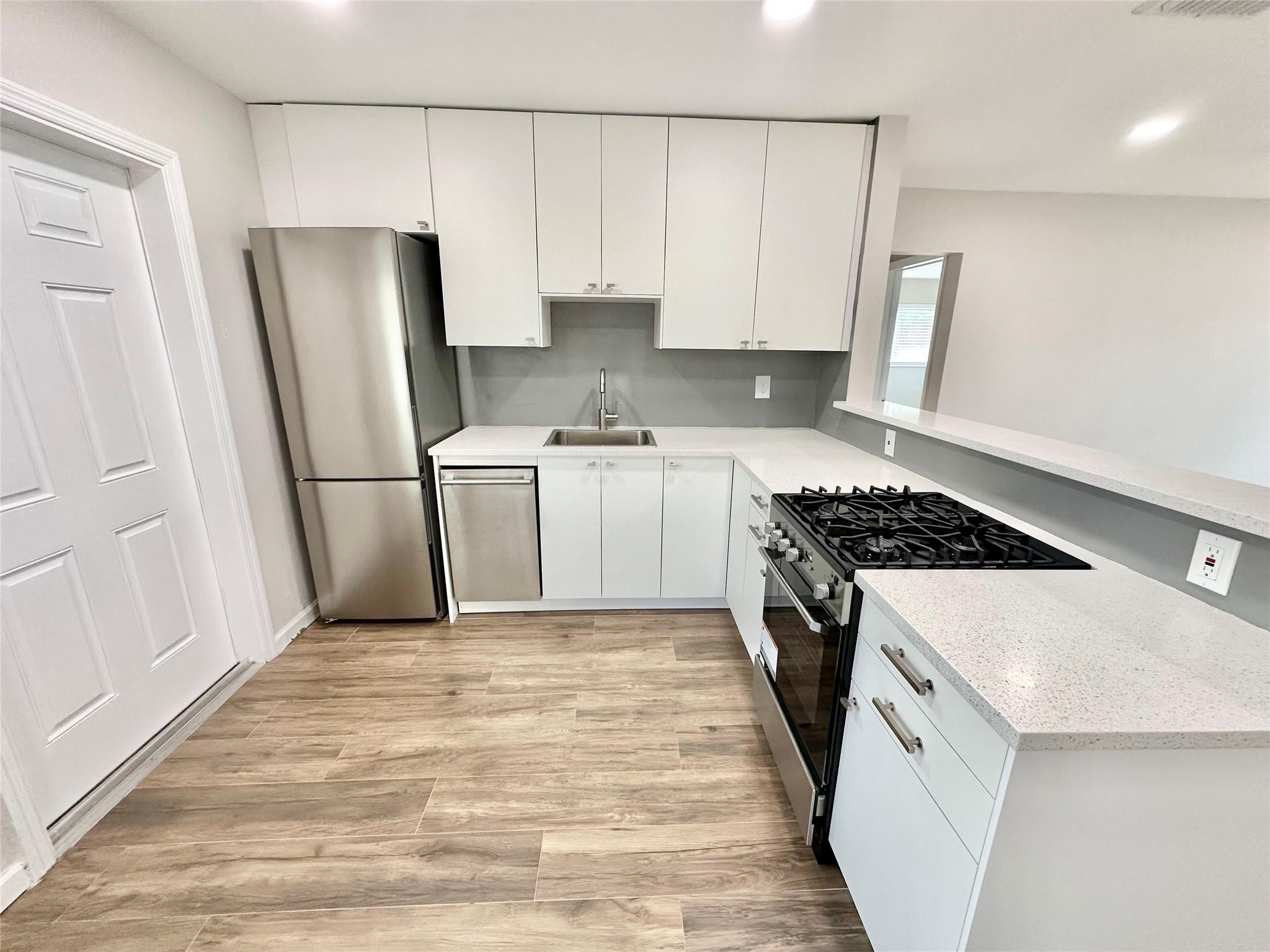 512 Southwest 11th Street, Unit A Hallandale Beach, FL 33009 - Photo 6 of 15 a kitchen with a stove a refrigerator and a sink