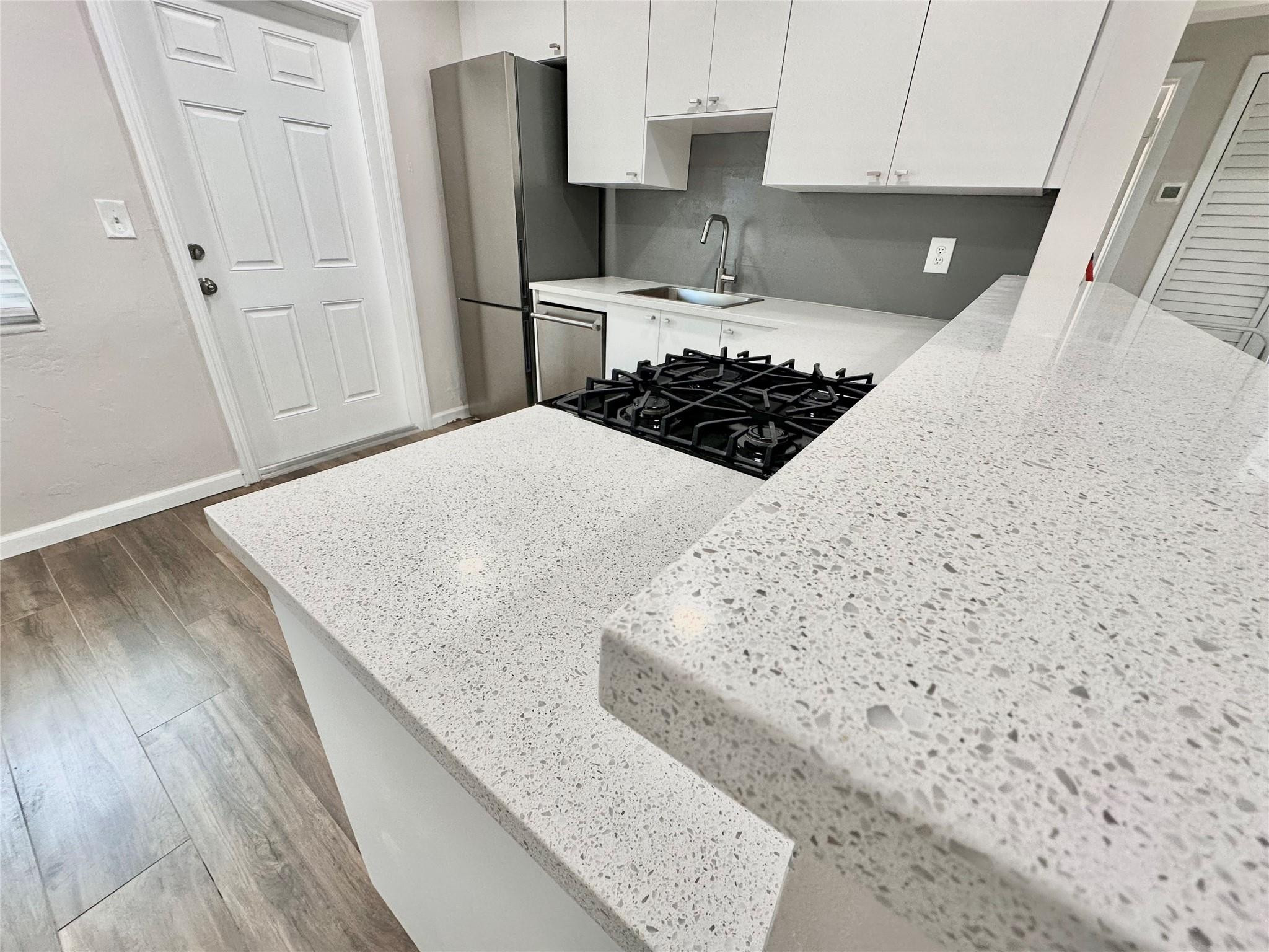 512 Southwest 11th Street, Unit A Hallandale Beach, FL 33009 - Photo 8 of 15 a kitchen with a stove a refrigerator and wooden floor