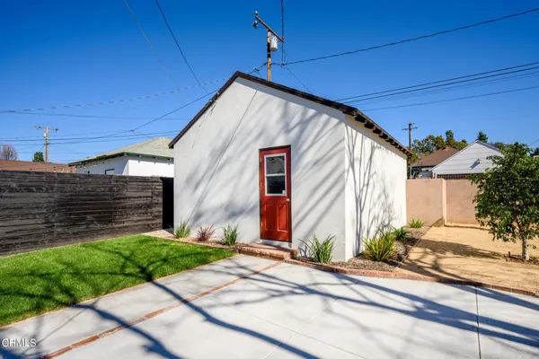 a view of house with backyard and tree